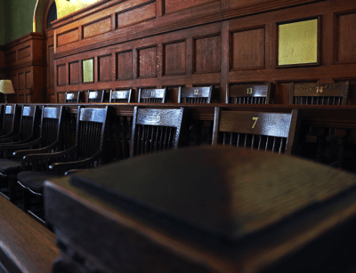 Wooden jury box with numbered seats in a traditional courtroom setting.
