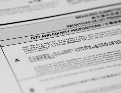 The image shows a close-up of a bilingual (English and Chinese) official document with a title CITY AND COUNTY PROPOSITIONS and a question for a public vote.