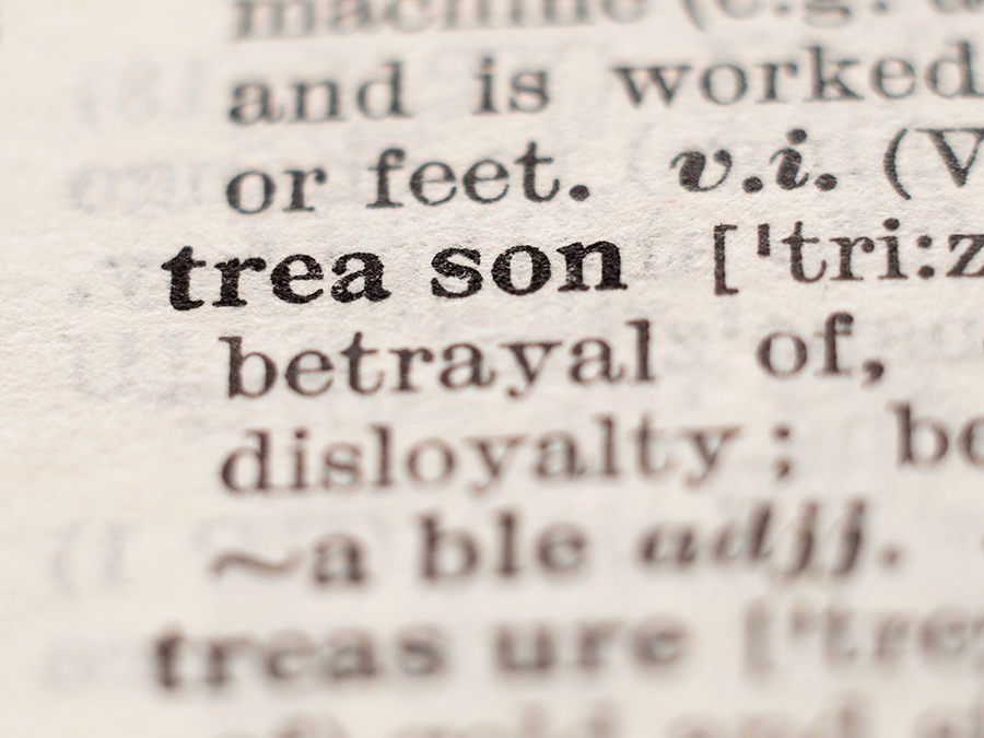 The image shows a close-up of a dictionary definition of the word treason, highlighting the word and its phonetic pronunciation.