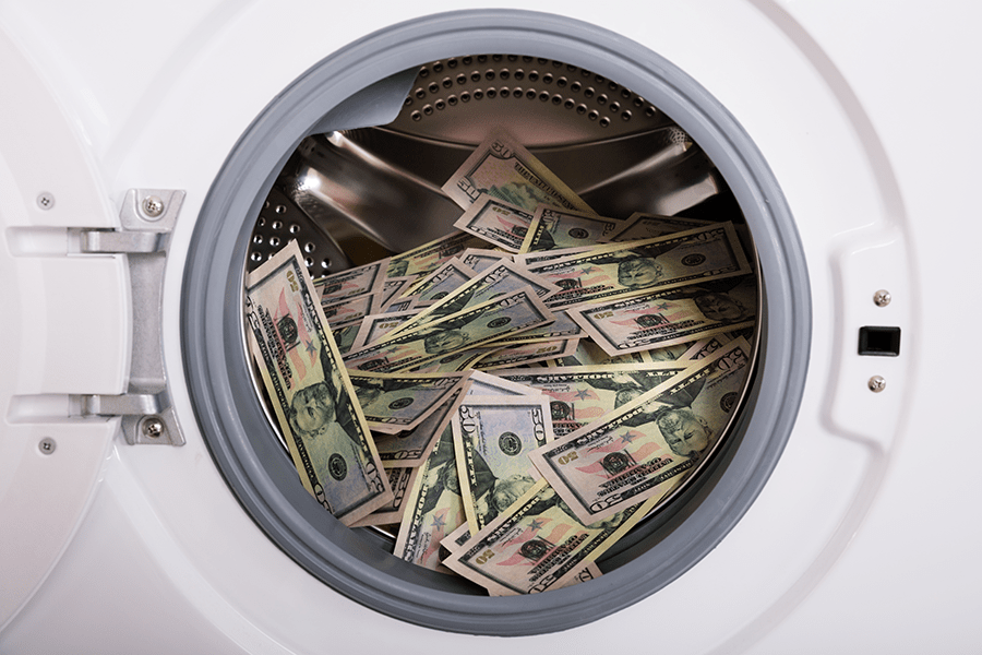 A washing machine drum is filled with a large amount of US dollar bills.